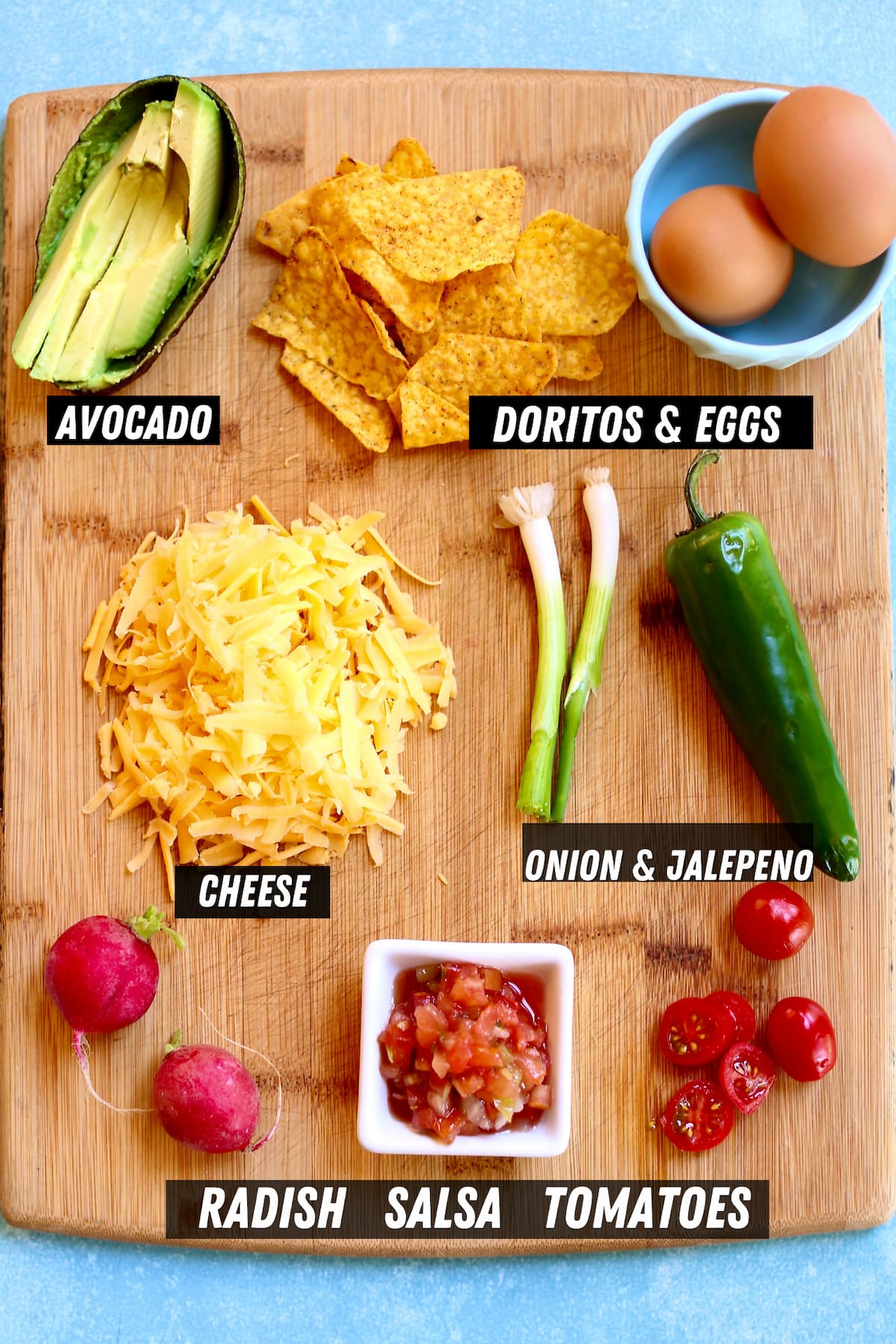 a cutting board with ingredients for nachos.