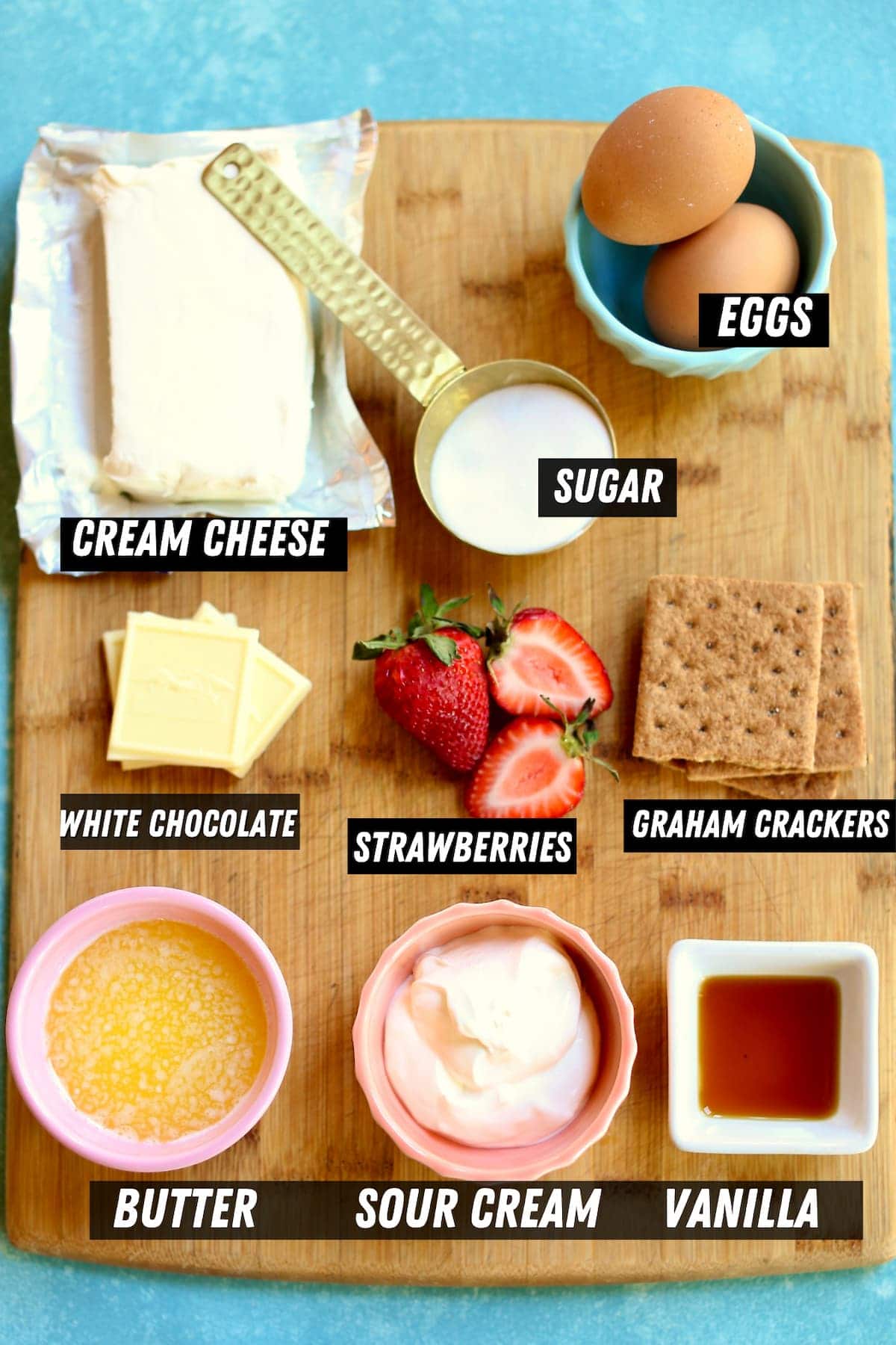 a cutting board with ingredients for a cheesecake.