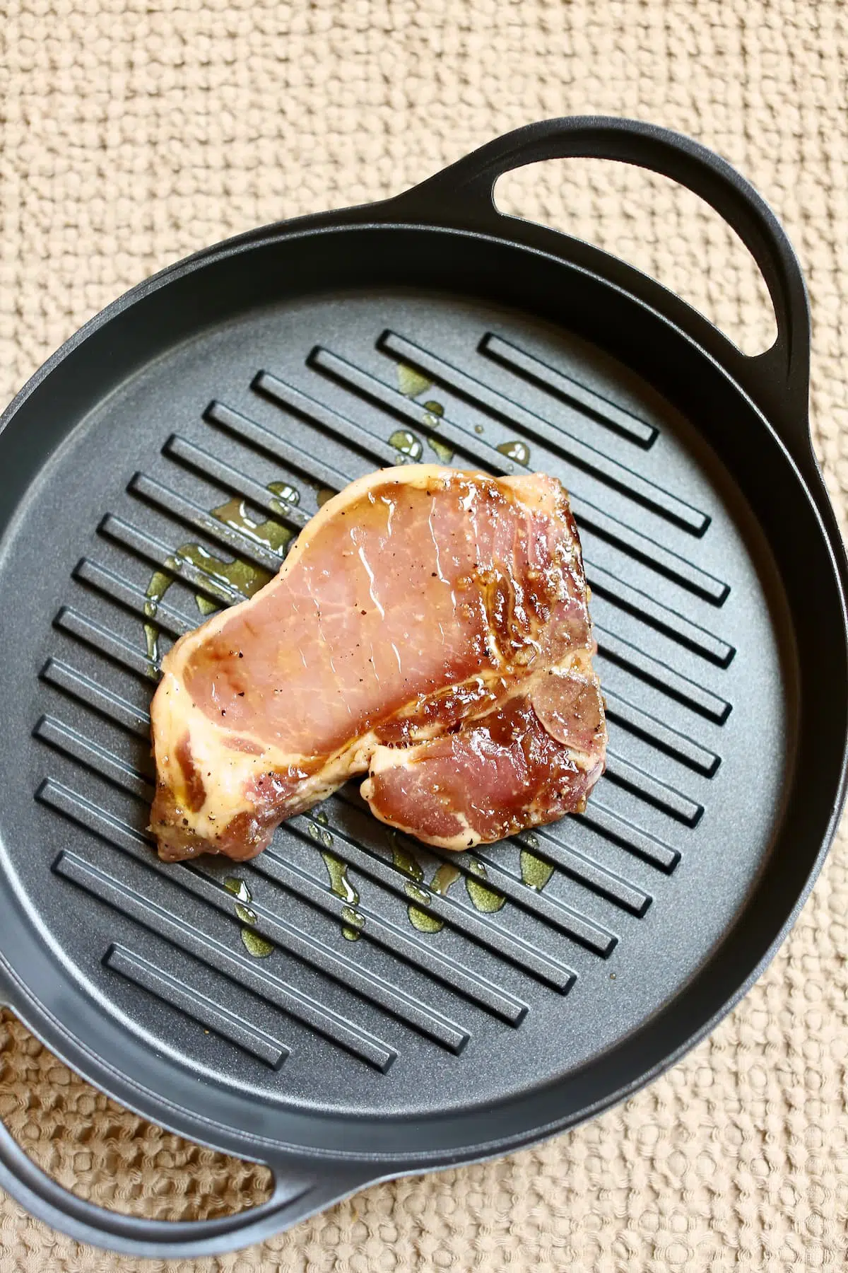 an uncooked pork chop in a grill pan.