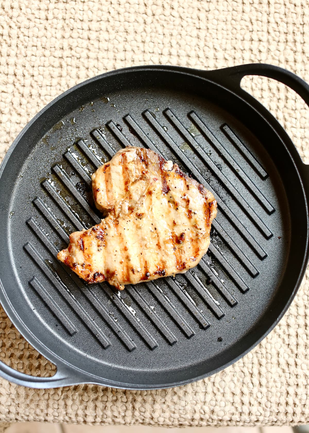 a cooked pork chop in a grill pan.