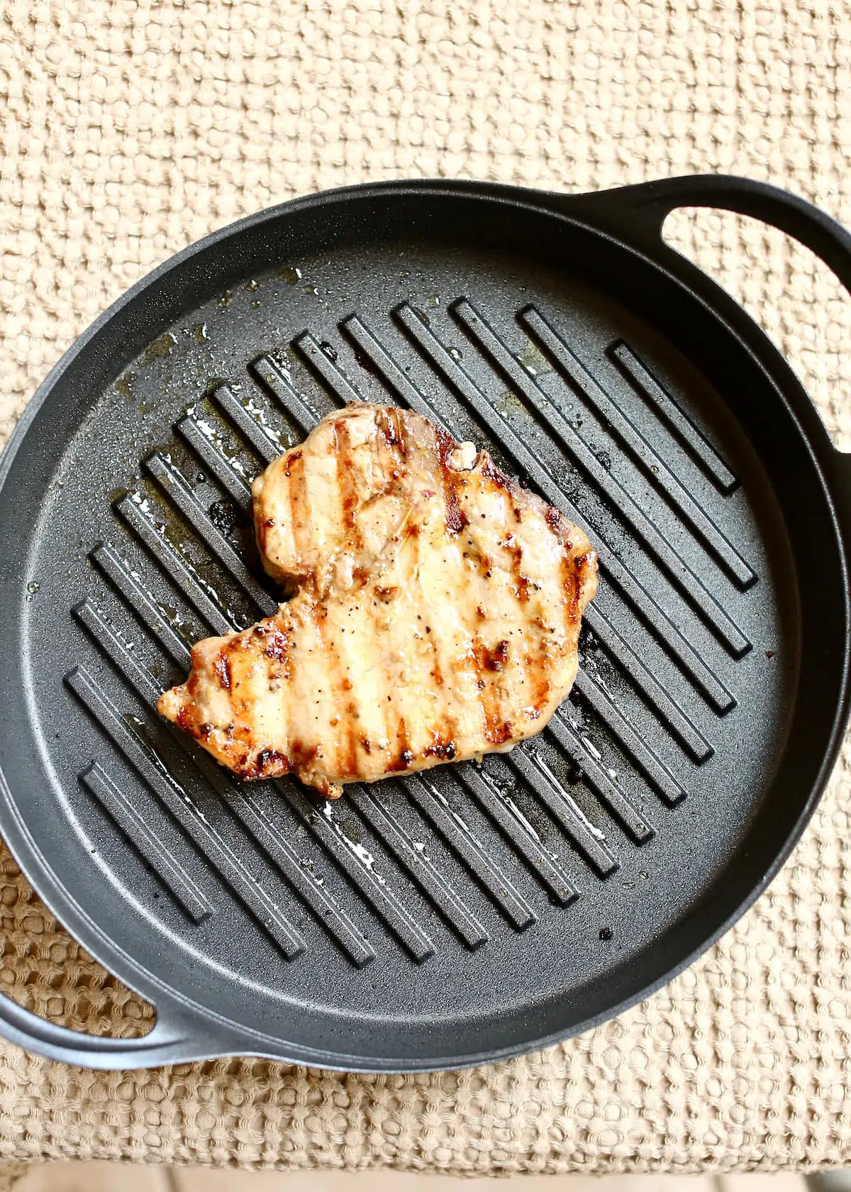 a cooked pork chop in a grill pan.