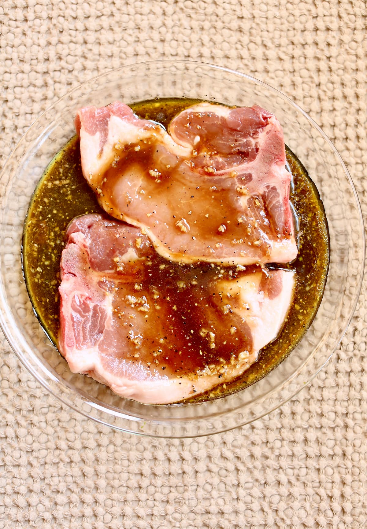a pork chop sitting in a brown sugar marinade.
