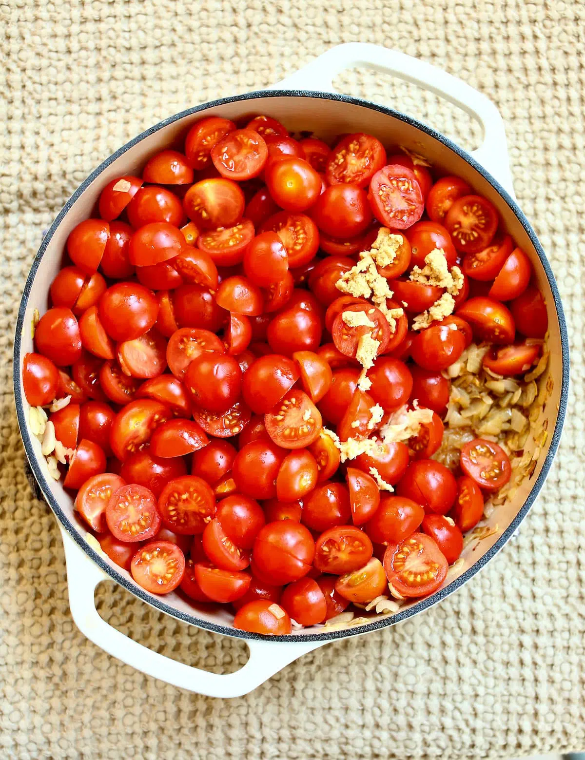 a skillet of cherry tomatoes, raw with garlic.