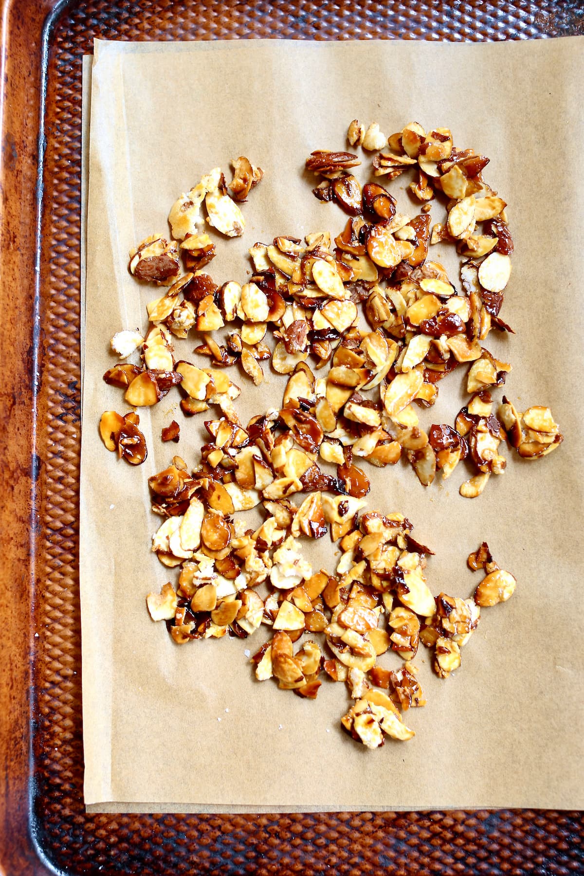 a baking sheet with candied almonds on it.