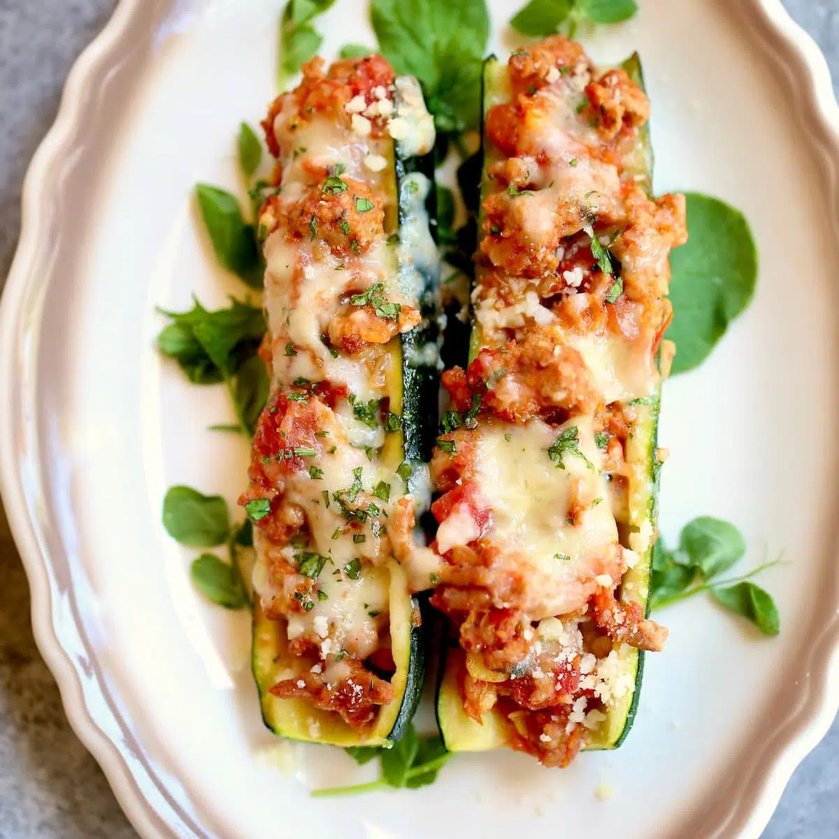 a plate with two stuffed zucchini on it.