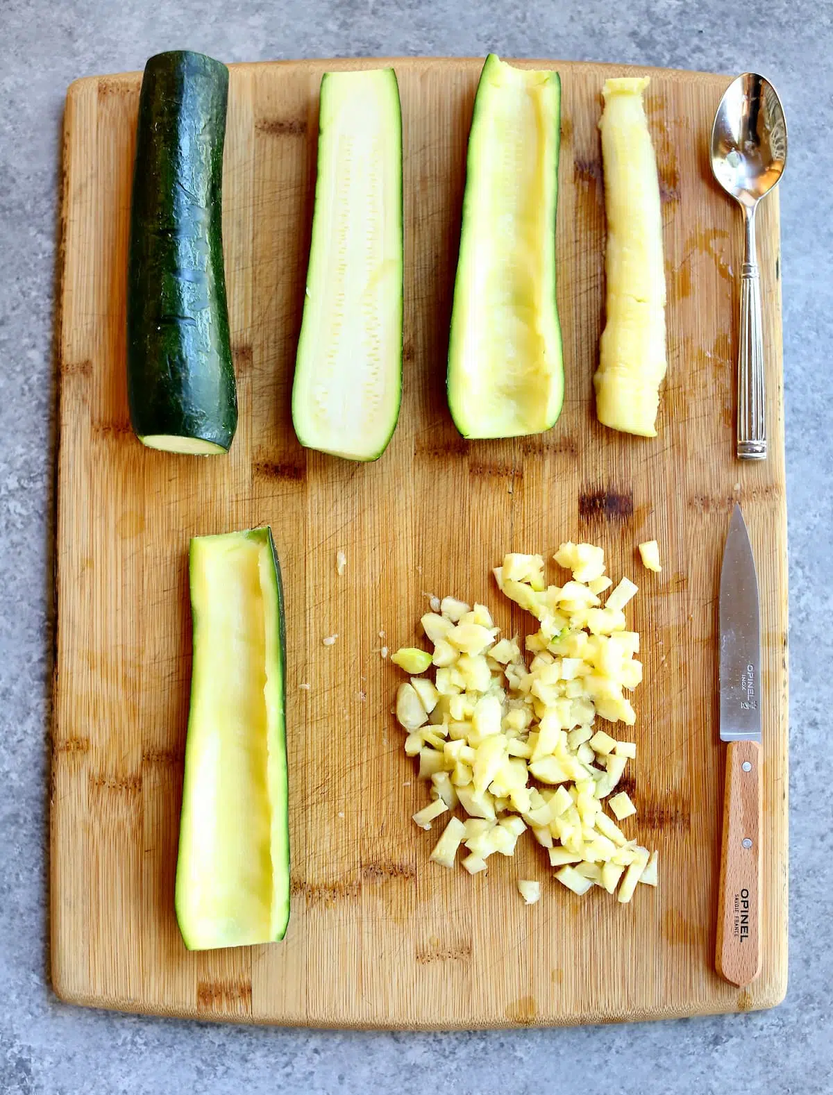 a board with raw zucchini boats on top and cut zucchini.