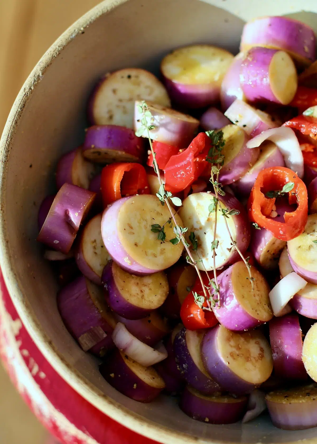 a bowl of uncooked eggplant and peppers.