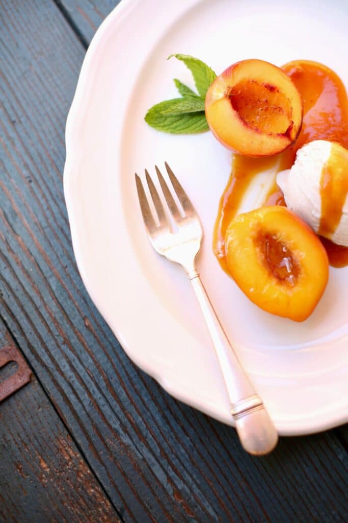 a plate with nectarines and ice cream on it.