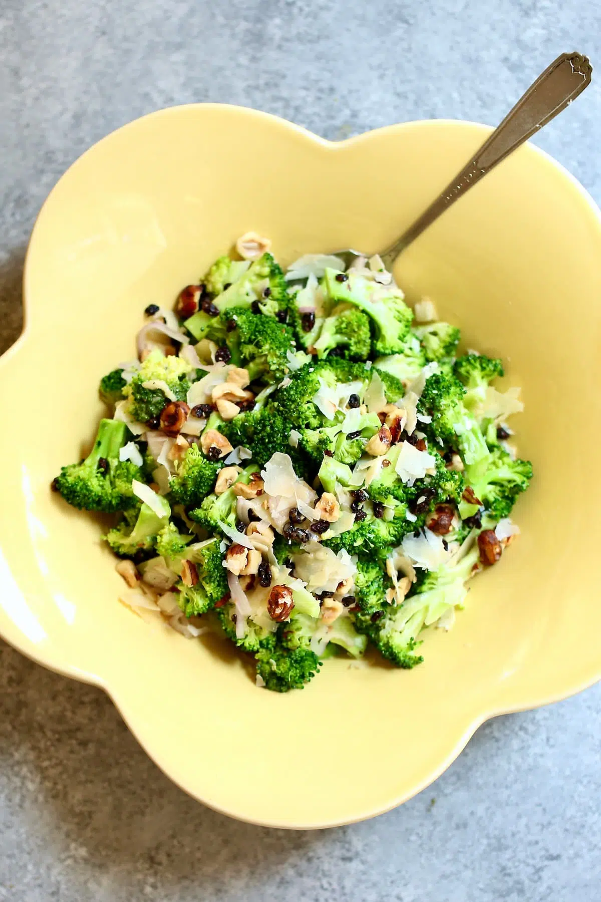 a yellow bowl with broccoli salad inside it. 