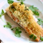 a white plate with stuffed salmon and lemon.