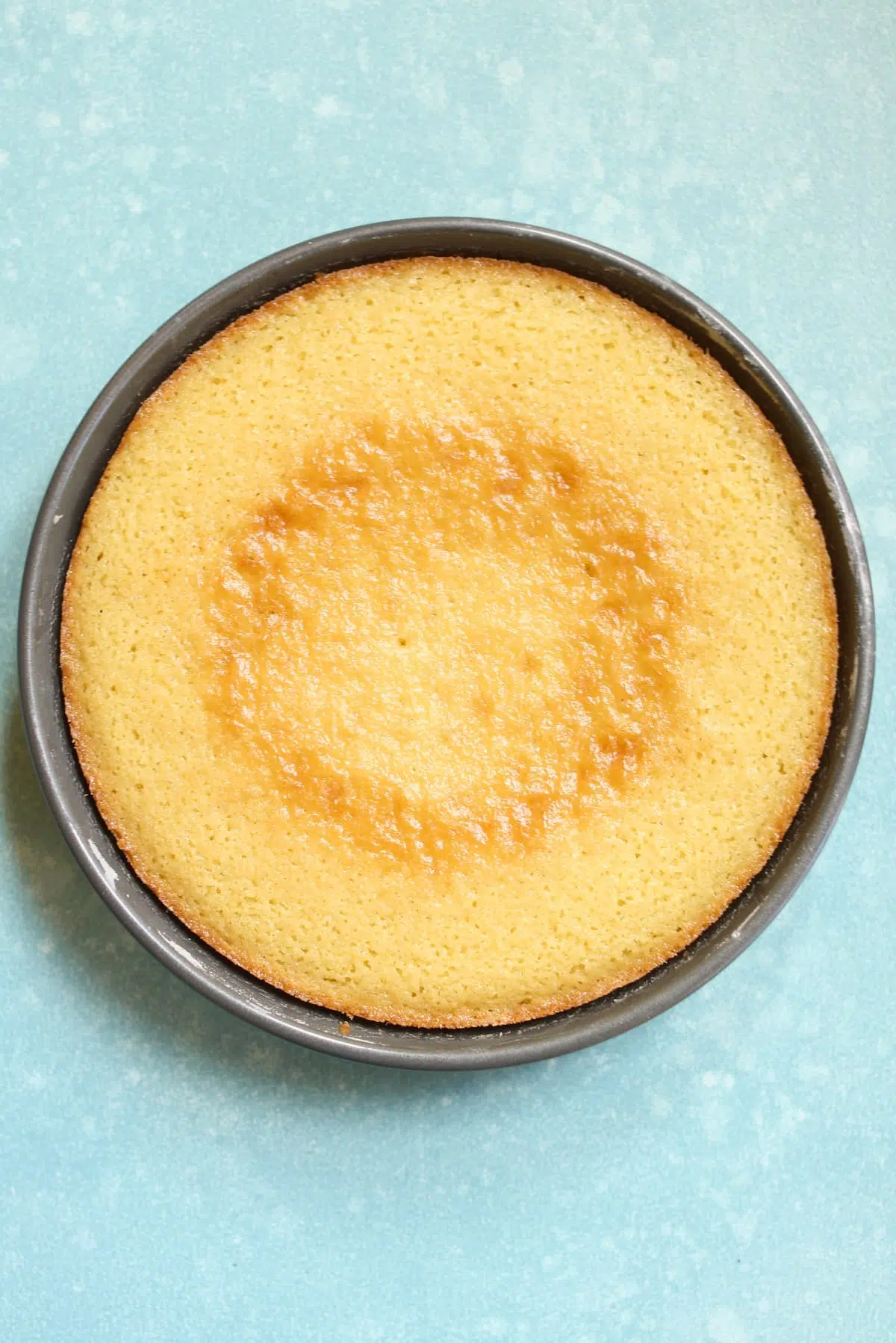 a cooked cake in a pan on a blue table.