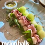 a blue tray of melon ball appetizers.