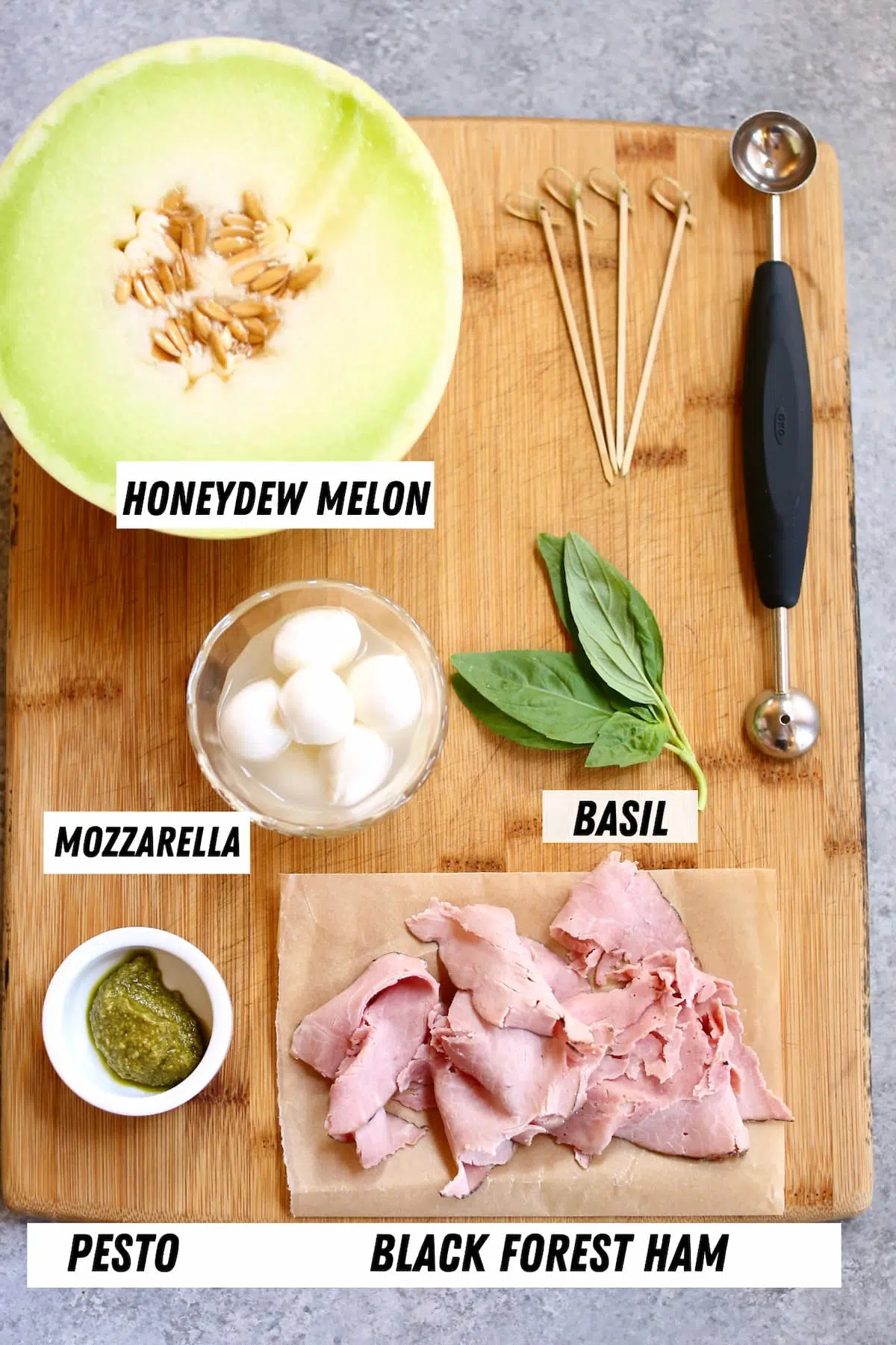 a board with ingredients on it, melon, ham and fresh mint and mozzarella cheese.