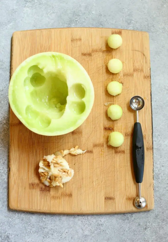 a cutting board with a honeydew melon on it, cut out.