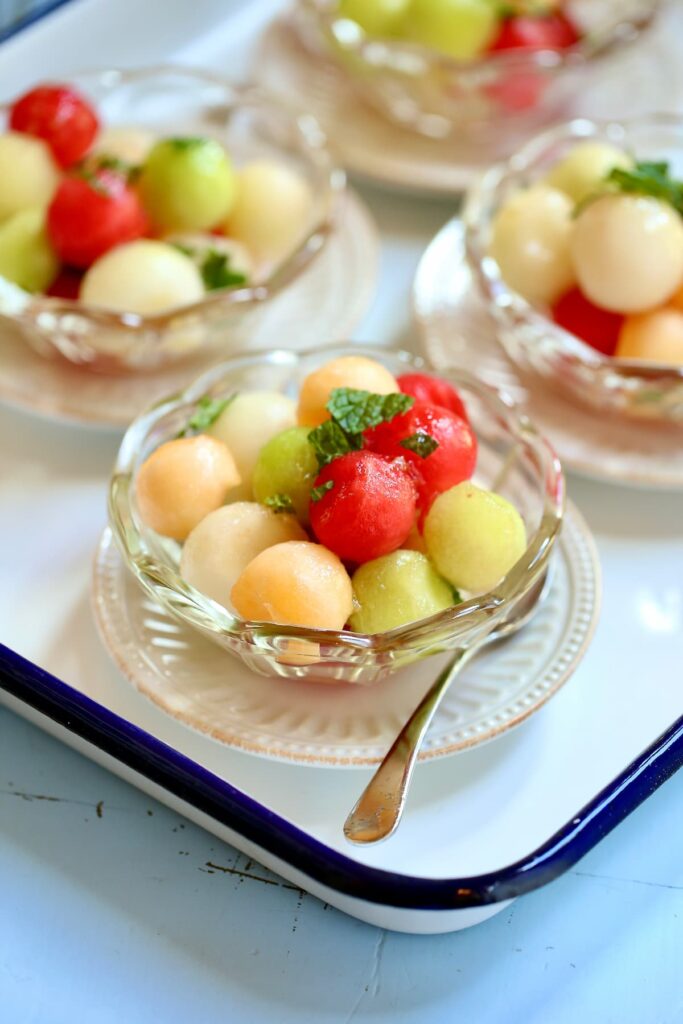 small bowls of fruit salad with melons.