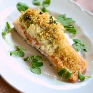 a finished dish of stuffed salmon on a white plate.