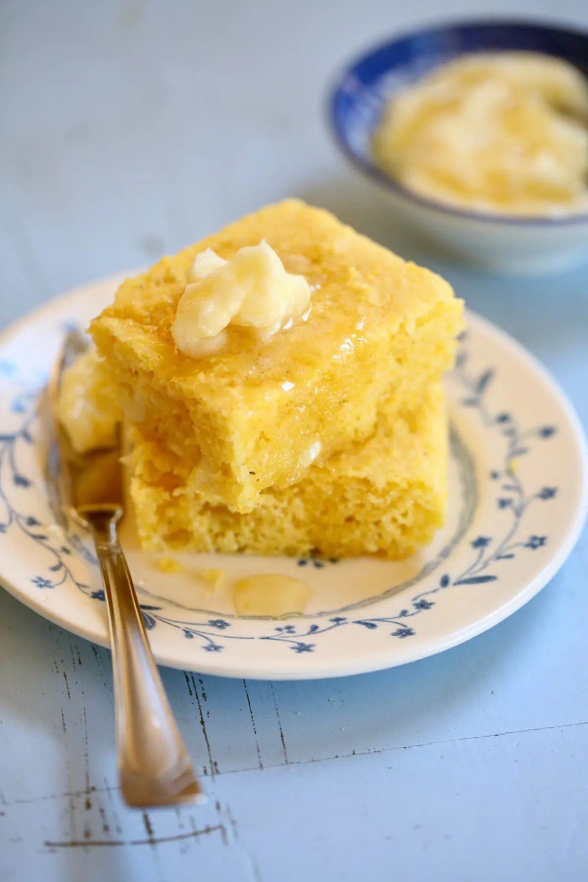 a close up photo of cornbread and honey butter on a plate.