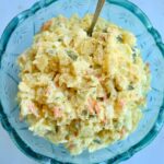 a blue bowl with potato salad in it.