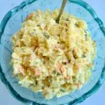 a blue bowl with potato salad in it.