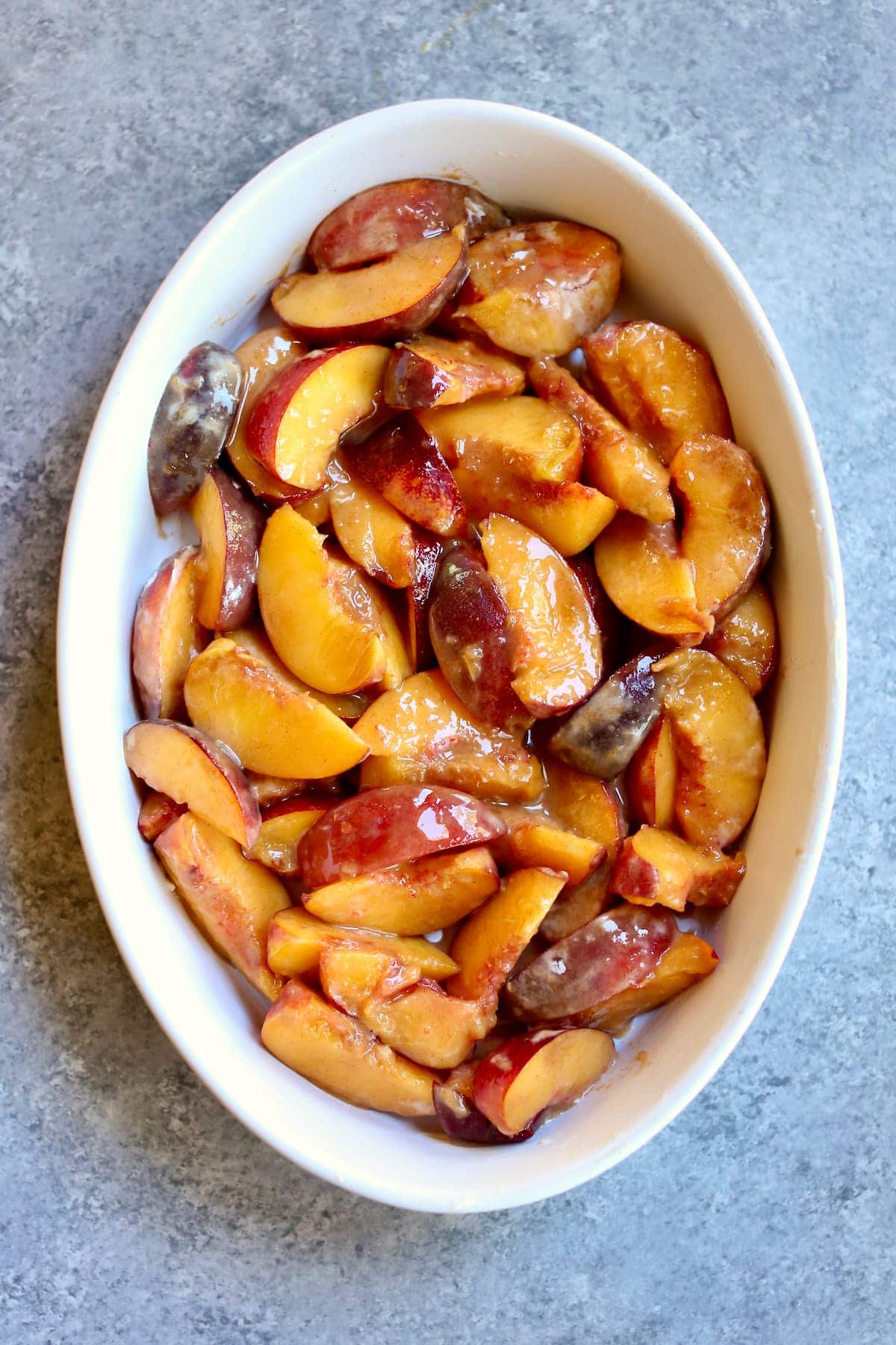 a baking dish with sliced peaches.
