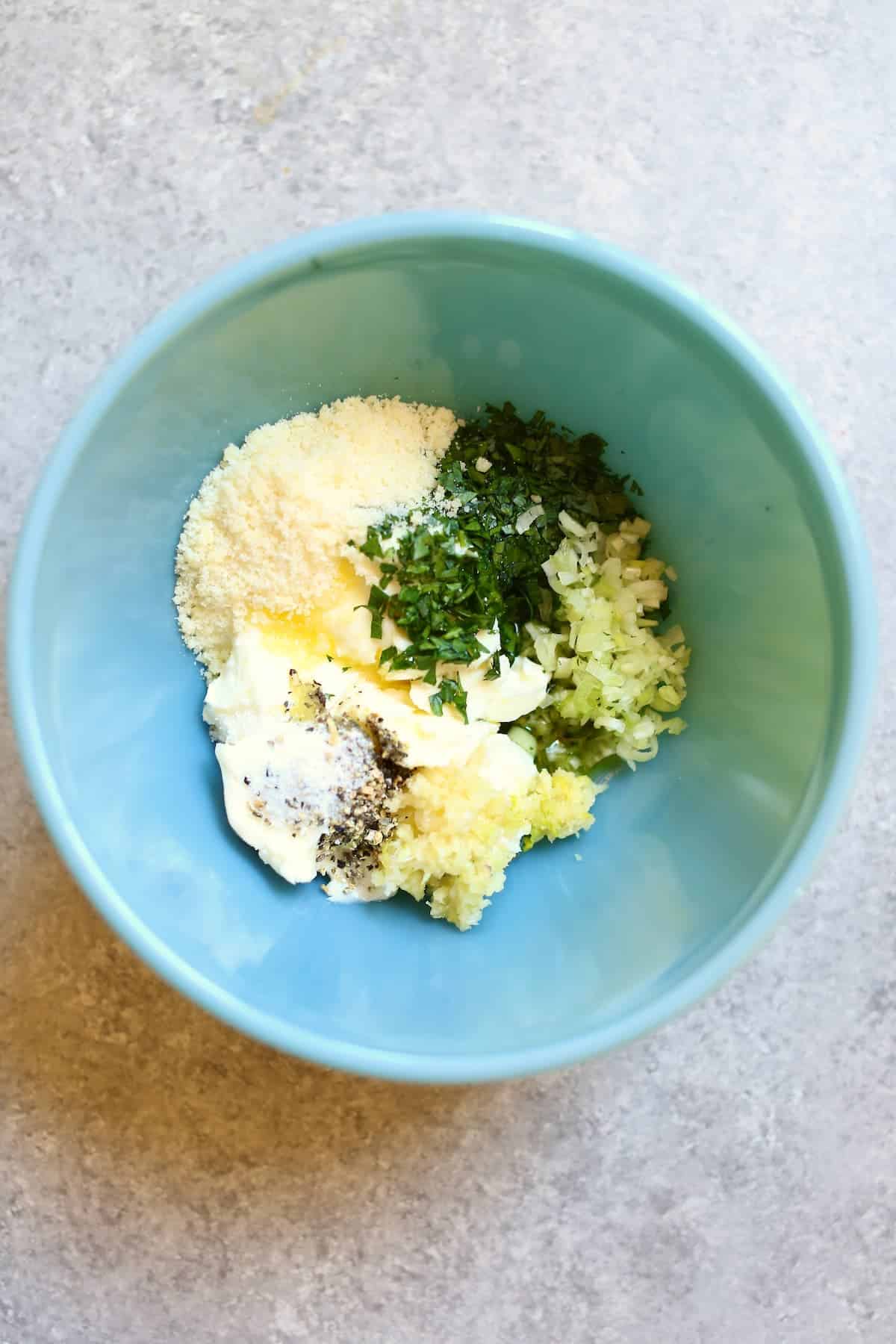 a blue bowl of garlic butter ingredients.