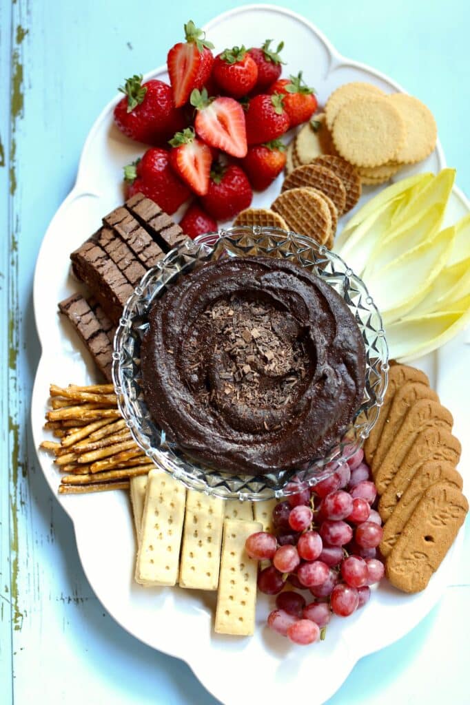 a tray of brownie dip with cookies and berries.