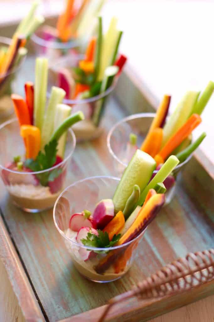 a tray of veggie cups with hummus.