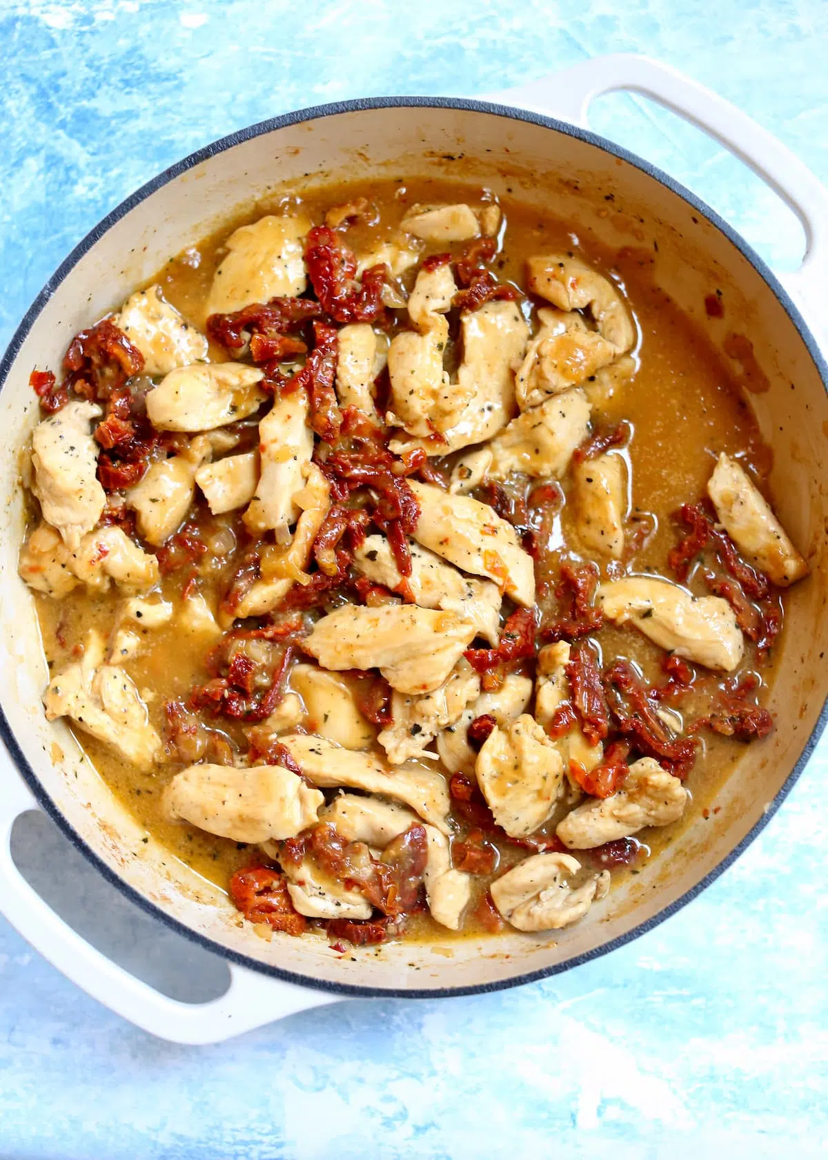 a skillet of chicken and sun dried tomatoes