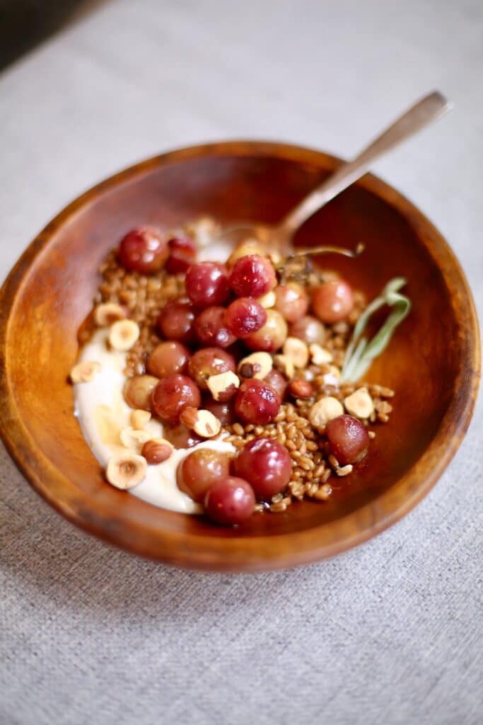 a wooden bowl of grains and yogurt.