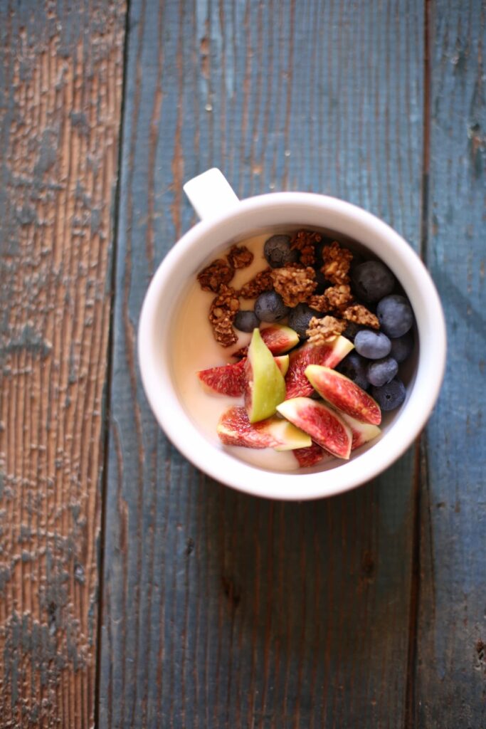 a small bowl of yogurt and berries and figs.