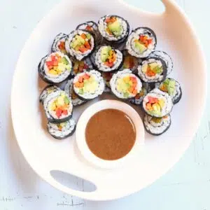 a square image of veggie sushi rolls.