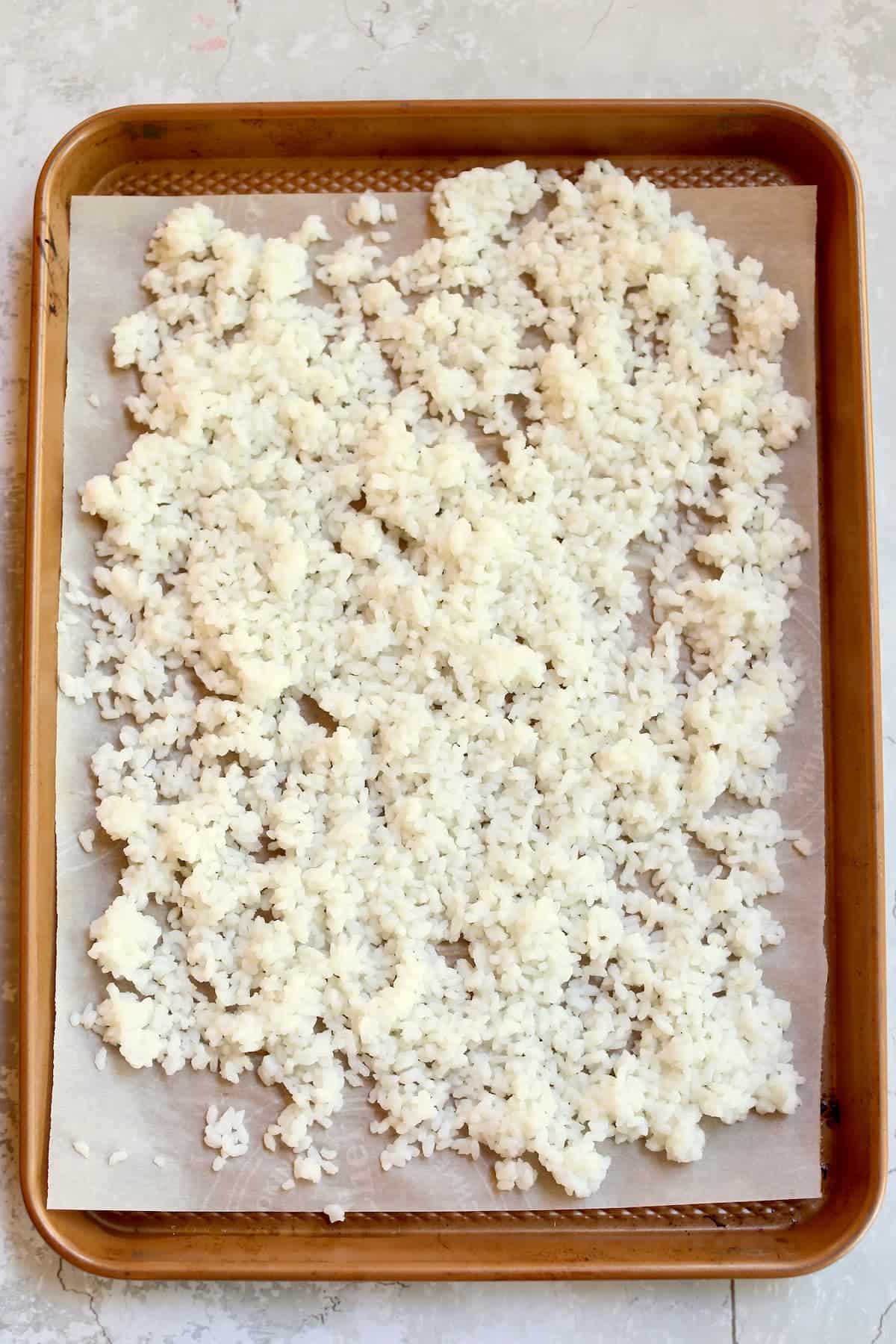 a baking sheet with sushi rice on it.