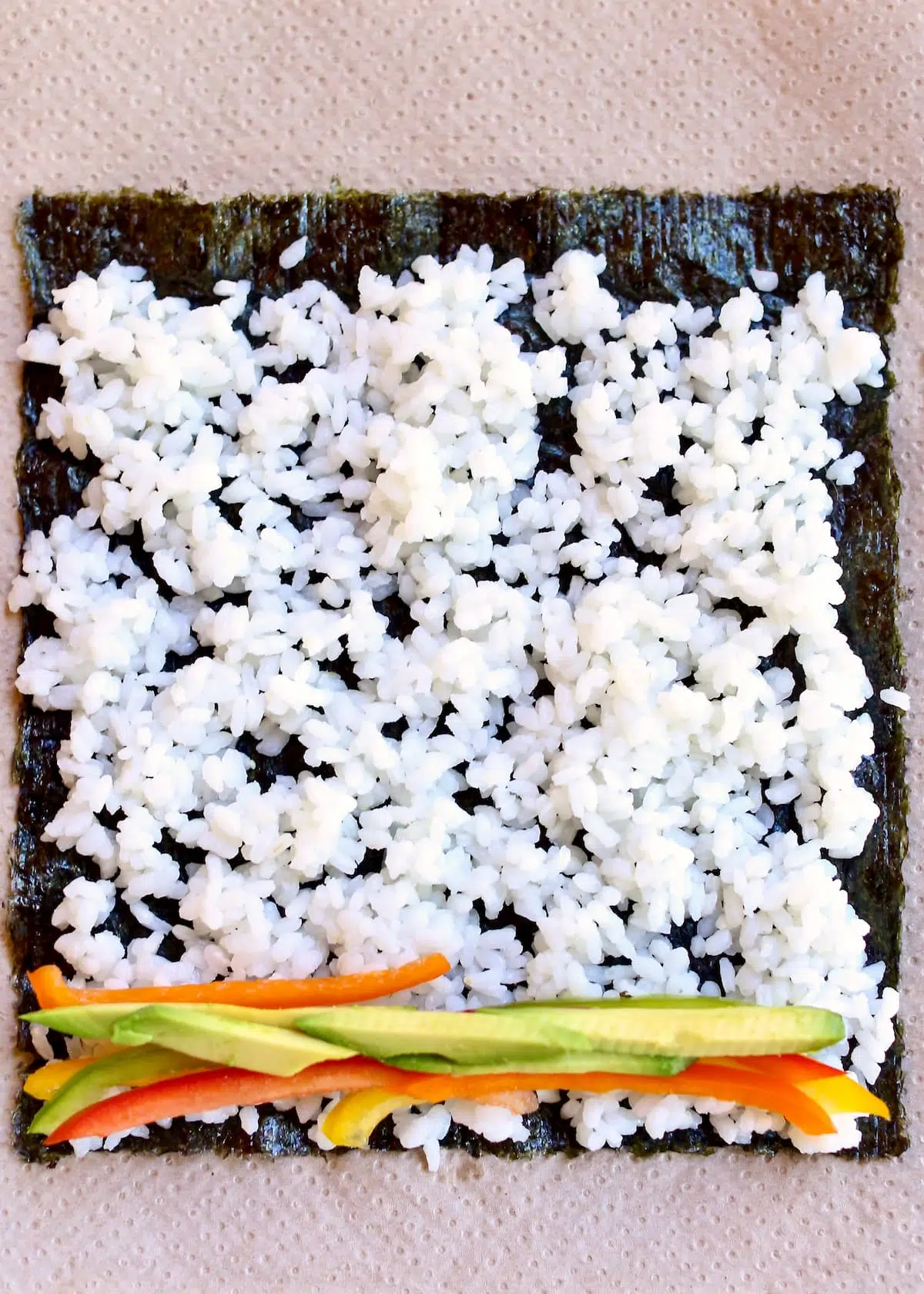 a seaweed sheet with rice and vegetables on it.