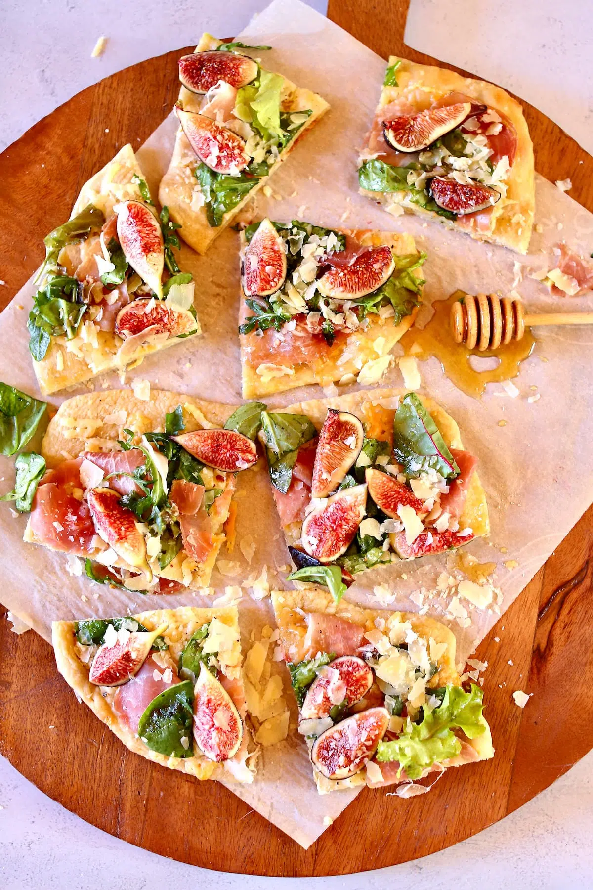 a wooden serving tray of fig prosciutto pizza.