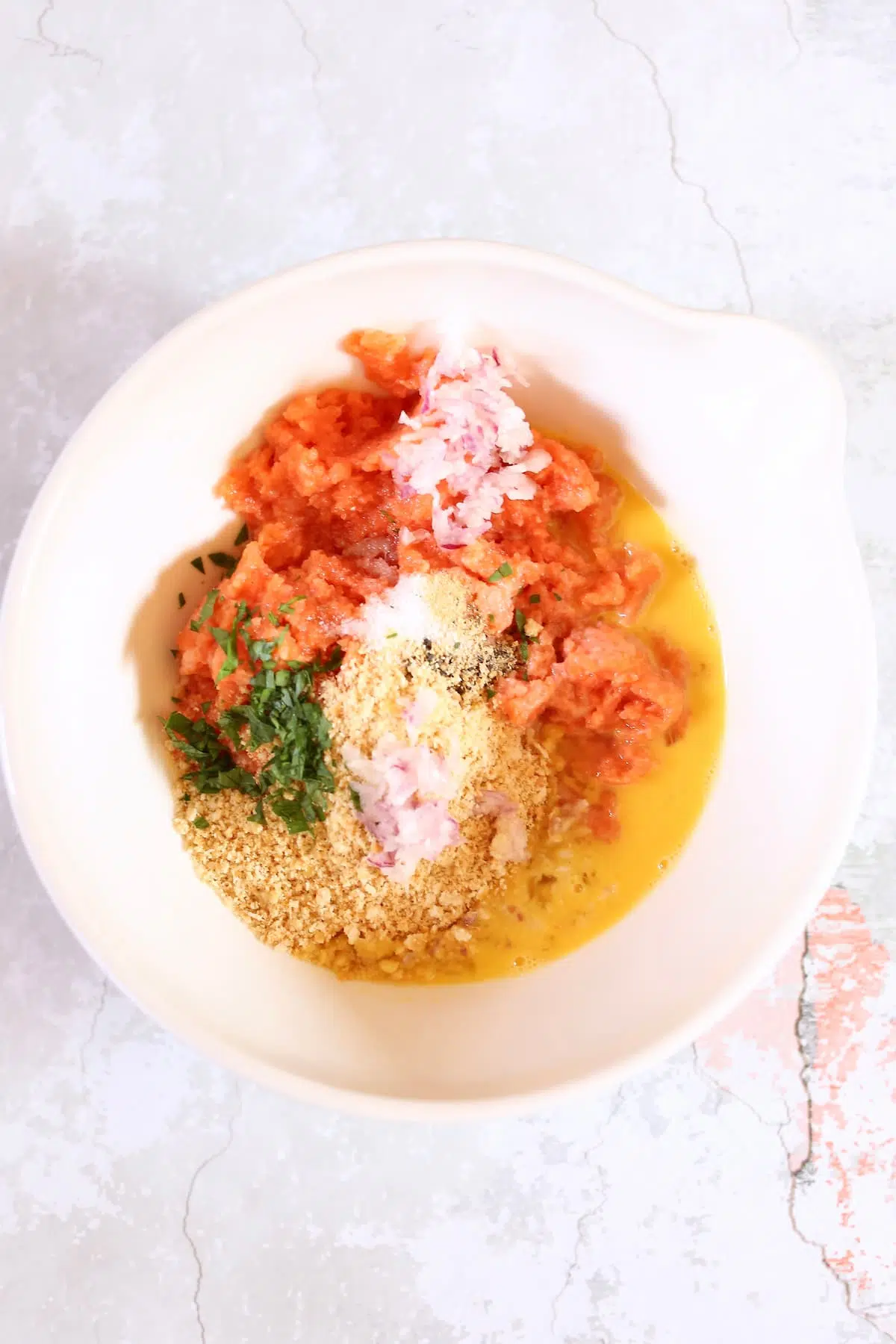 a white bowl of ingredients for salmon patties.