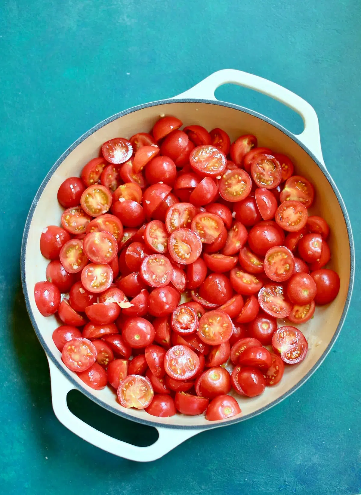 a skillet with uncooked tomatoes in it.