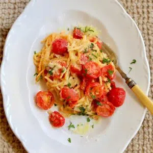 a square photo of baked spaghetti pasta.