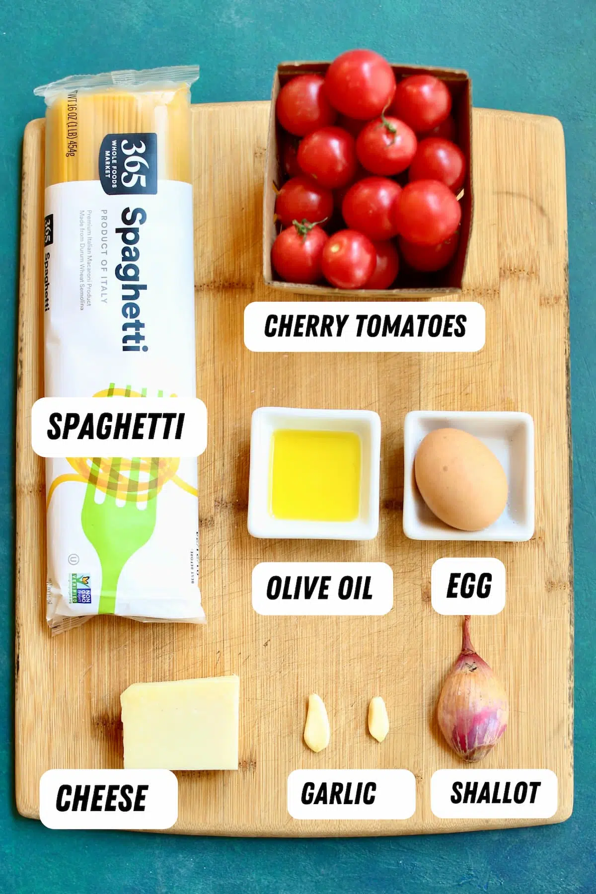 a cutting board with ingredients for spaghetti pie.