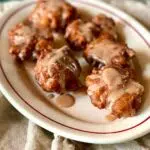 a side view of apple fritters on a platter.