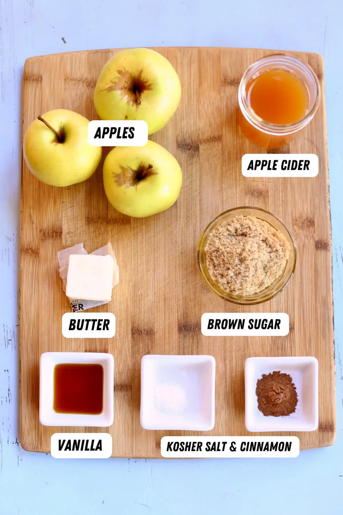 a cutting board of ingredients to make applesauce.