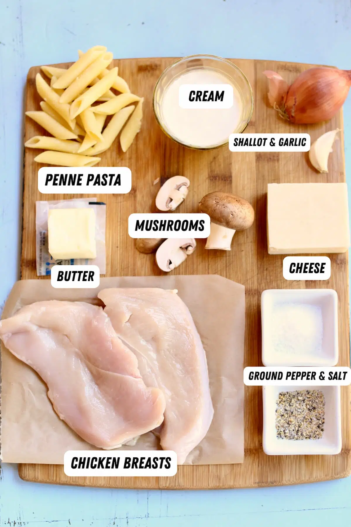 a cutting board of ingredients for chicken pasta.