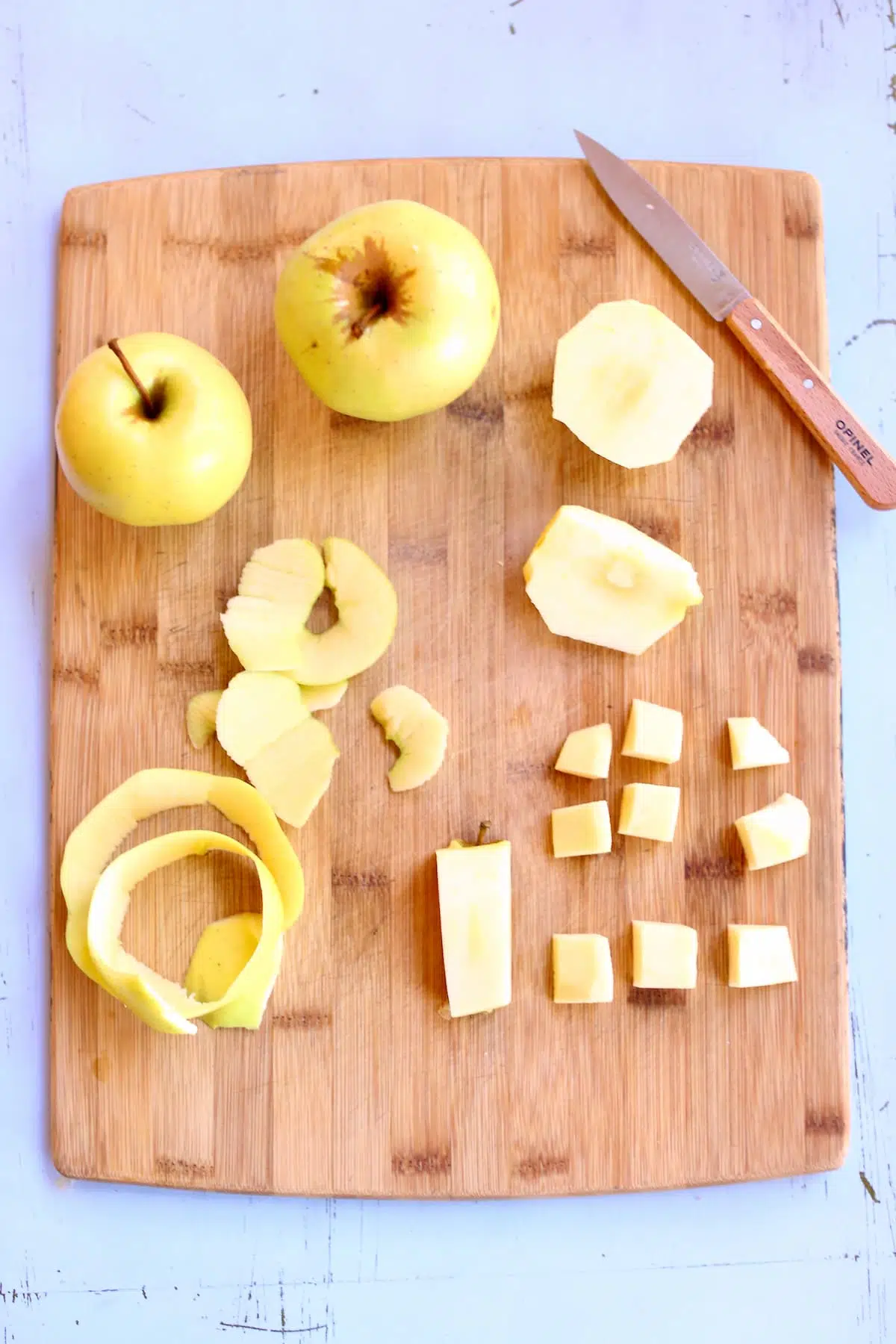 a cutting board with cut up apples on it and a knife.