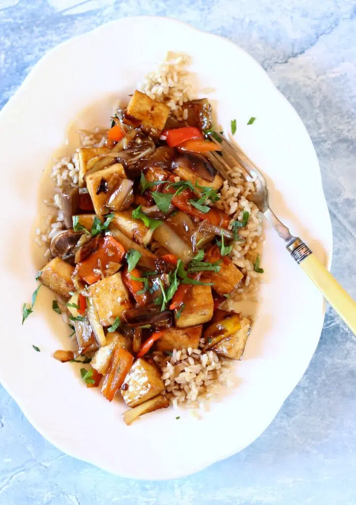 a white plate of tofu and eggplant.