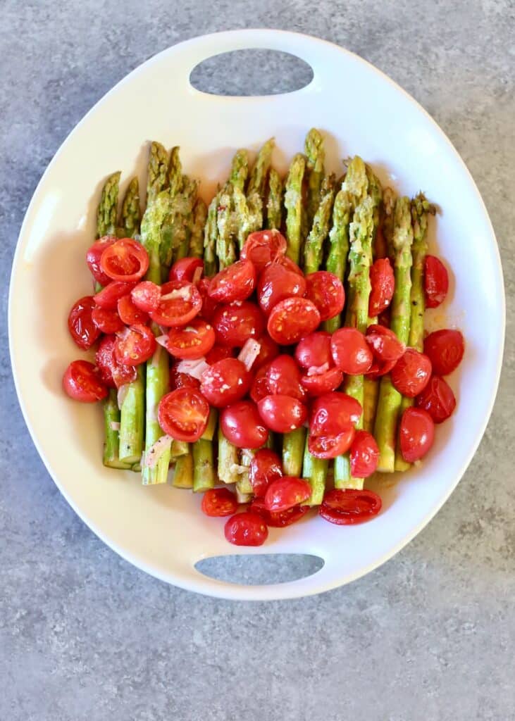 an overhead view of asparagus with tomatoes.
