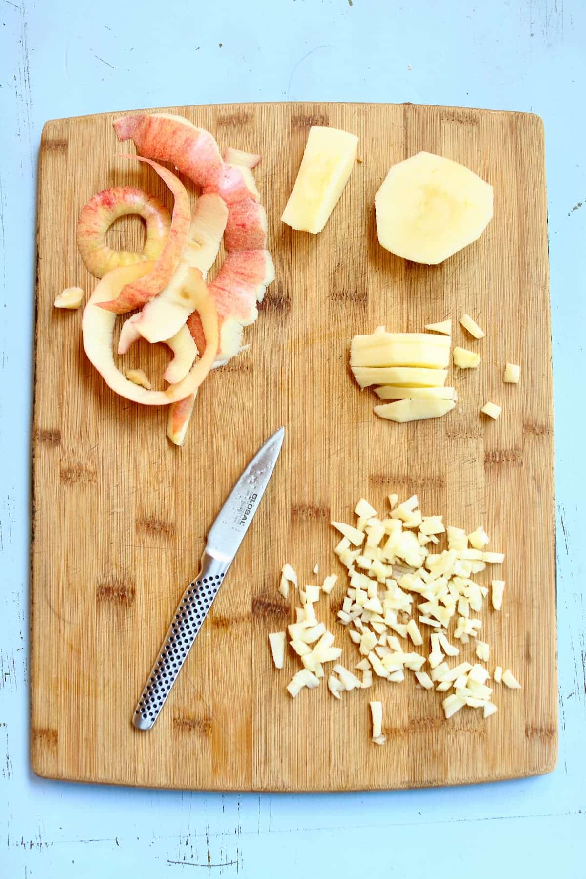 a cutting board of apples being diced.