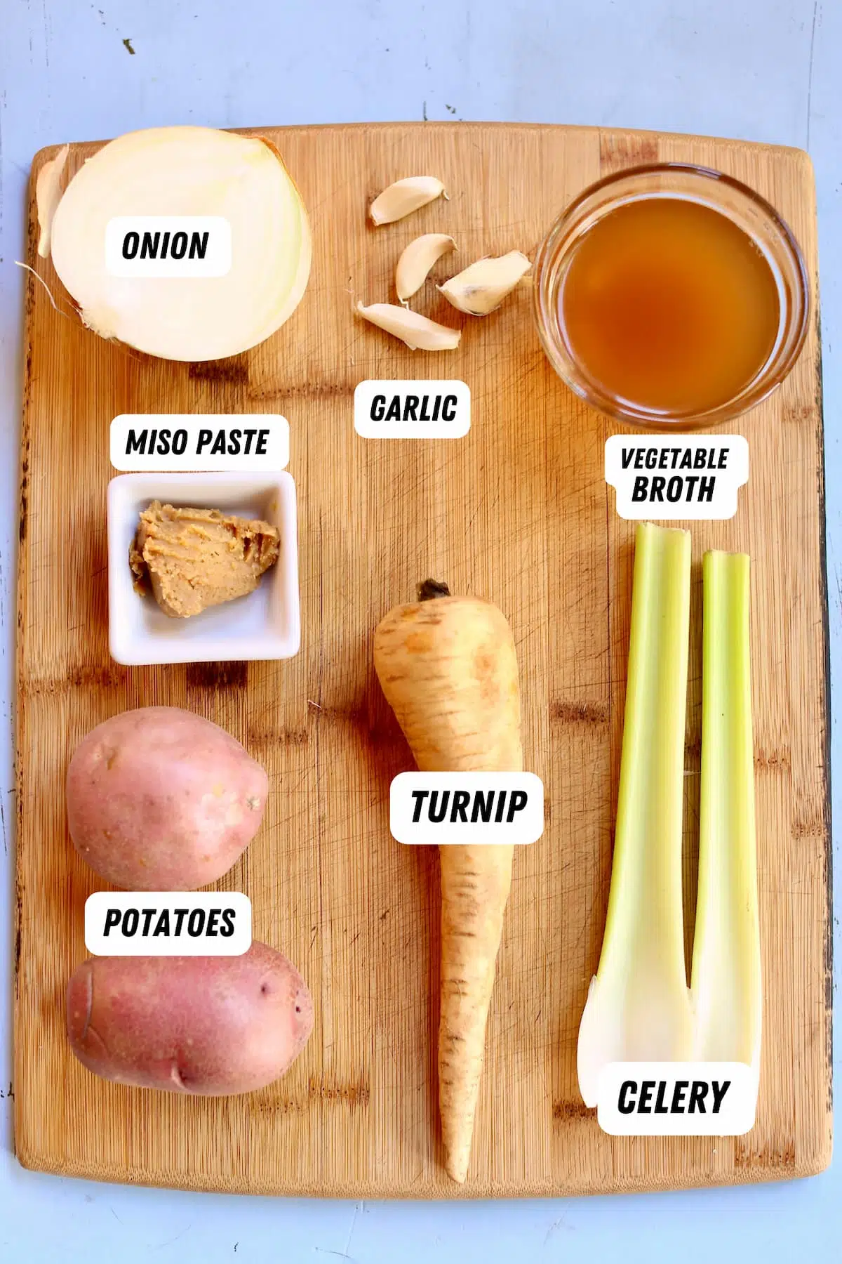 a cutting board with ingredients in it for soup.