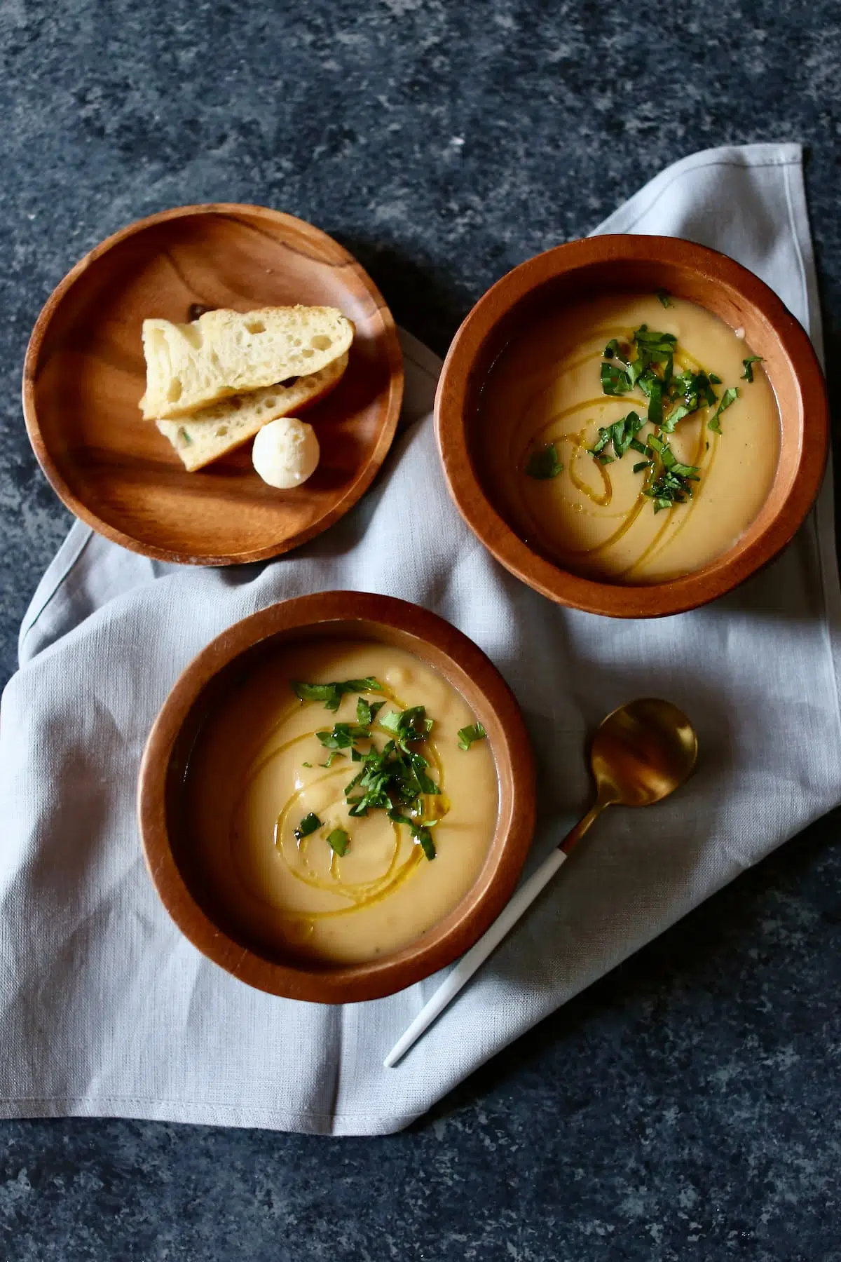 soup in wooden bowls with bread on a napkin.