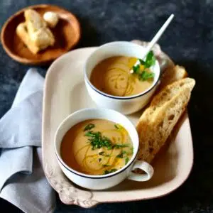 a square photo of two cups of soup.