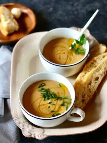 a square photo of two cups of soup.