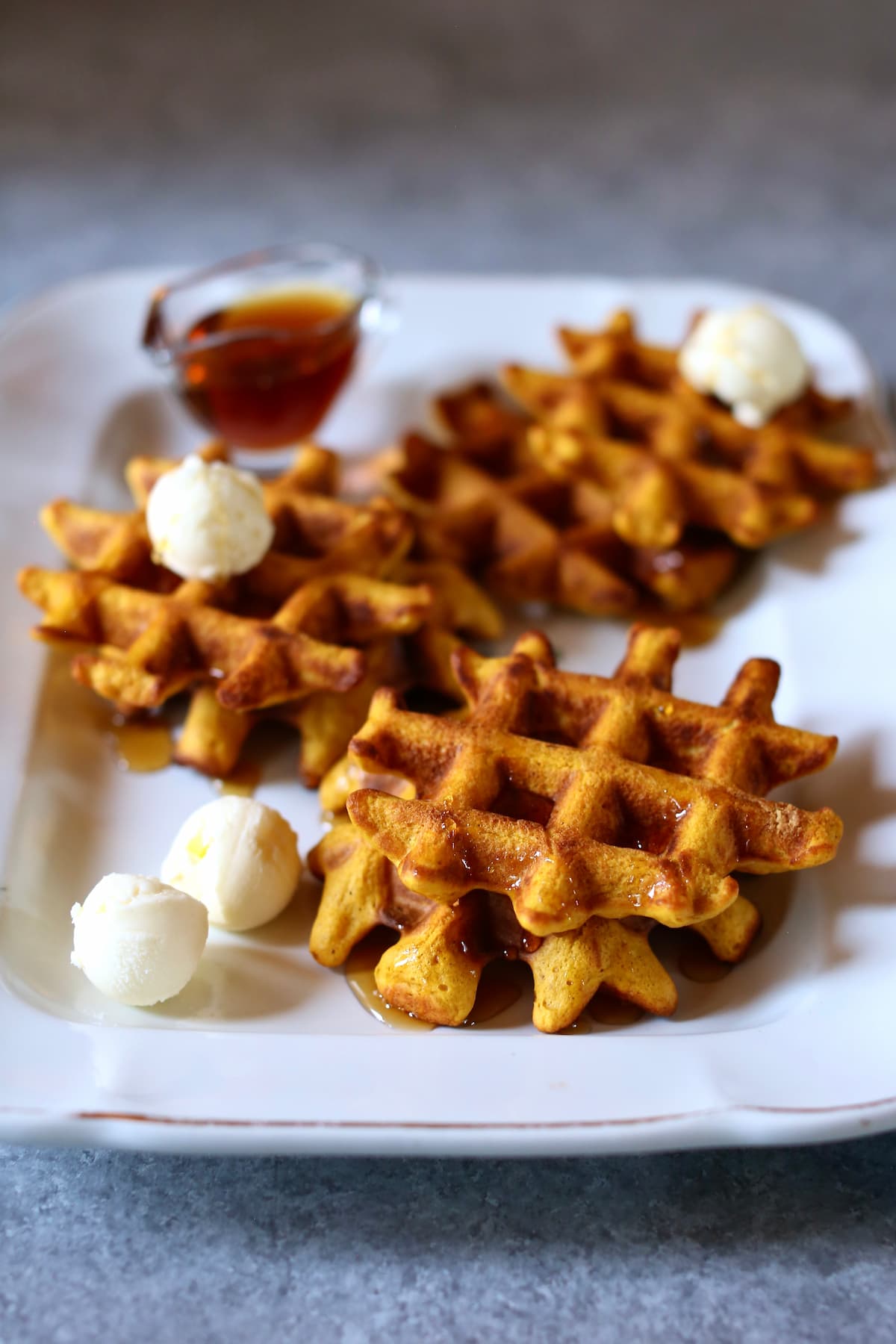 a white platter with pumpkin waffles on it.